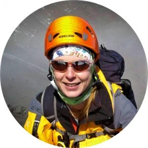 Elisabeth Gschösser with a yellow jacket, red sunglasses and orange mountaineer helmet